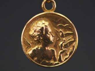 Vente aux enchères Médaille religieuse en or jaune, figurant un angelot aux oiseaux. Diam