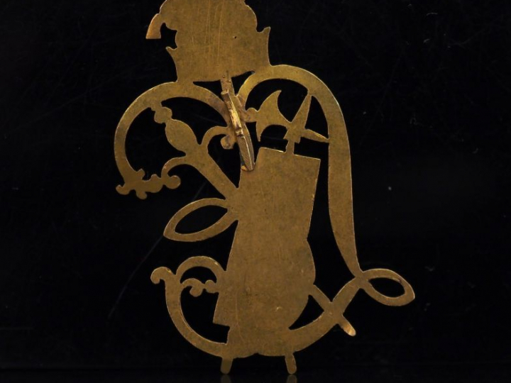 Elément de bijoux en or jaune en forme de monogramme agrémenté d'un tr