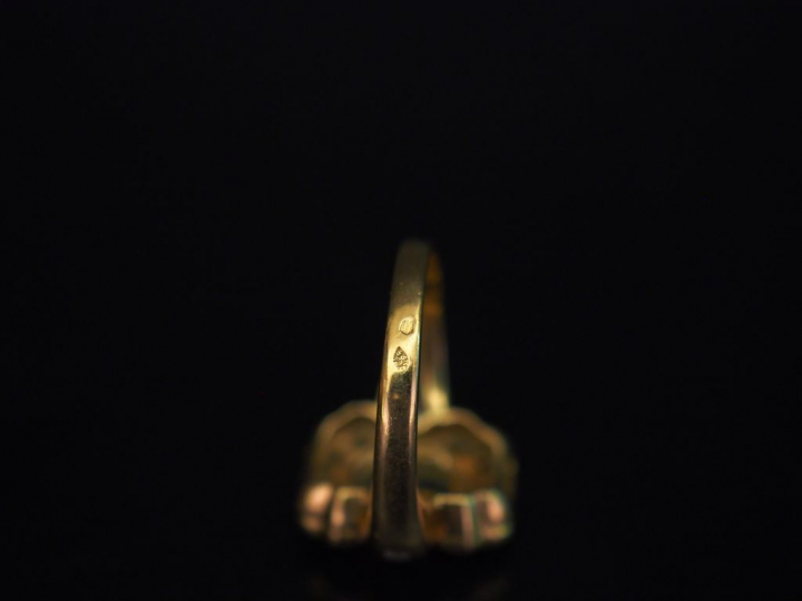 Bague en forme de nœud en or jaune, sertie en son centre d'une émeraud