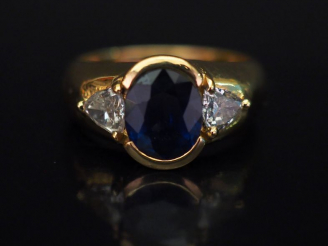 Vente aux enchères Bague jonc en or jaune, sertie en son centre d'un saphir épaulé de deu