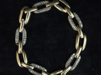Vente aux enchères Bracelet articulé en or blanc, à décor de maillons sertis de deux lign