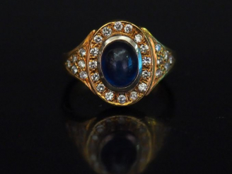 Vente aux enchères Bague en or jaune, sertie en son centre d'une pierre bleue en cabochon