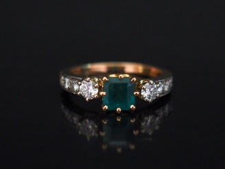 Vente aux enchères Bague jonc en or jaune, sertie en son centre d'une émeraude épaulée de