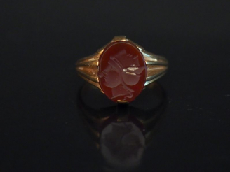 Vente aux enchères Bague en or jaune, sertie en son centre d'une intaille figurant deux v