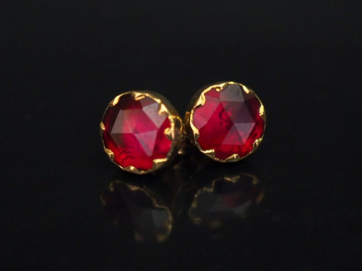 Paire de perce-oreilles en or jaune, sertis d'un grenat.  Diam. 0,8 mm