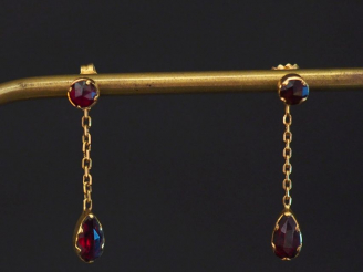 Vente aux enchères Paire de perce-oreilles en or jaune, sertis de deux grenats dont un en