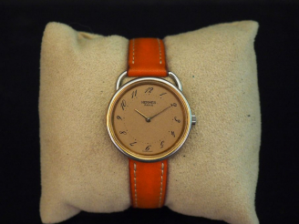 Vente aux enchères HERMES Montre bracelet de dame en acier, modèle arceau.  Cadran paille