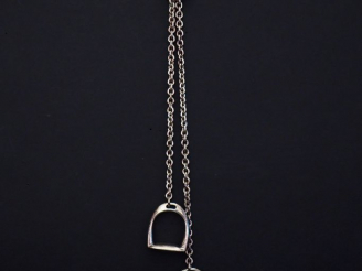 Vente aux enchères HERMES, Paris.  Collier cravate en argent, à décor de deux étriers en 