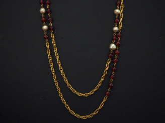 Vente aux enchères CHANEL  Sautoir en métal doré, maille tressée, agrémentée de perles d’