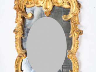 Vente aux enchères Glace Louis XV en bois sculpté et doré, à décor de palmettes, de rocai