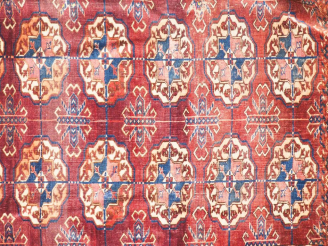 Vente aux enchères Tapis Boukhara fond lie de vin (usures). Dim. 228 x 154 cm