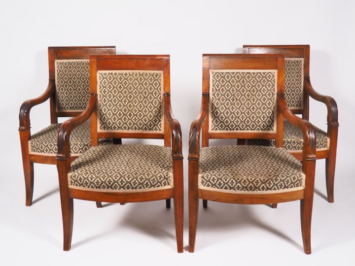 Suite de quatre fauteuils Empire en noyer, piétement sabre.