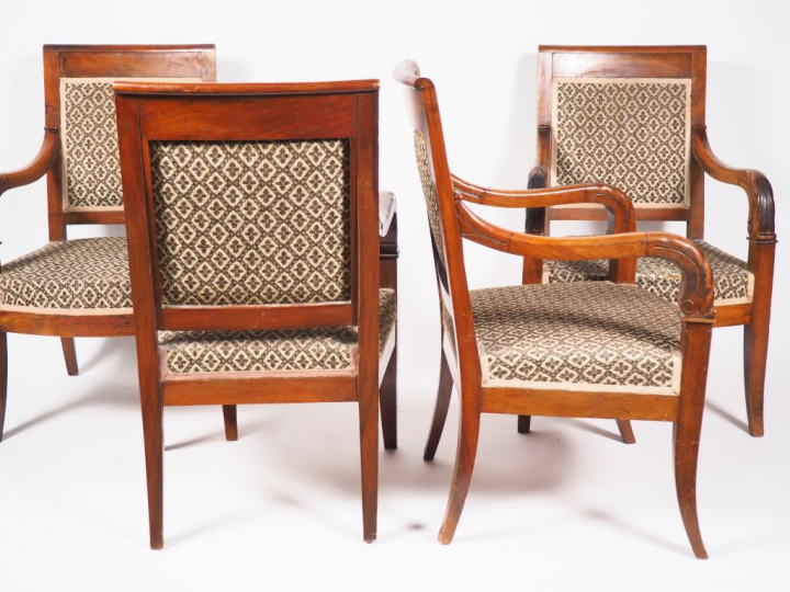 Suite de quatre fauteuils Empire en noyer, piétement sabre.