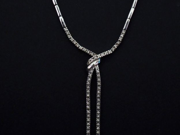 Collier articulé en or blanc, à décor en son centre d'un nœud de ruban