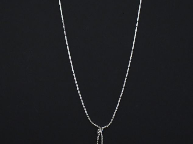 Collier articulé en or blanc, à décor en son centre d'un nœud de ruban