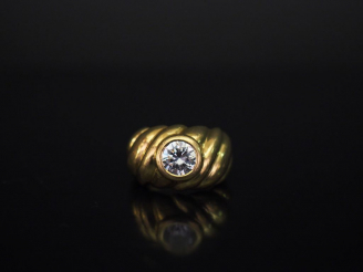 Vente aux enchères Bague en or jaune, à décor de côtes torses et sertie en son centre d'u