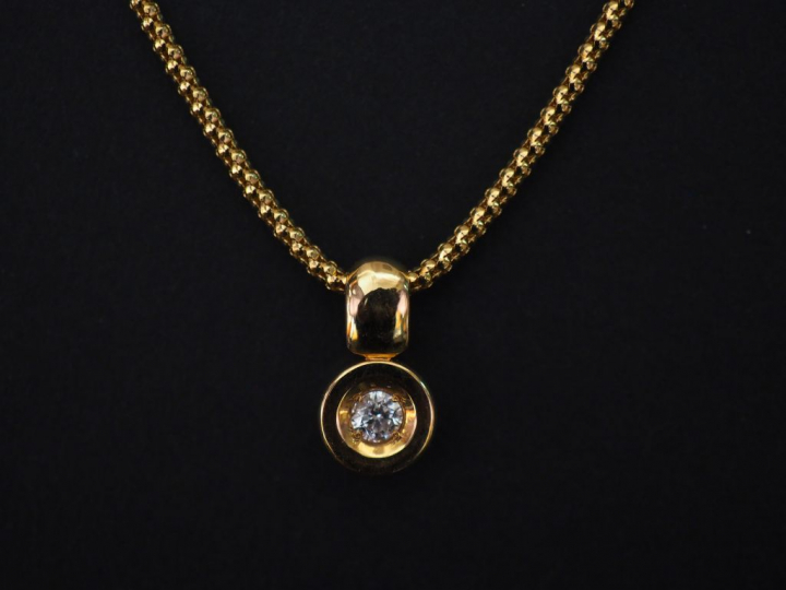 Pendentif en or jaune, orné en son centre d'un petit diamant serti clo