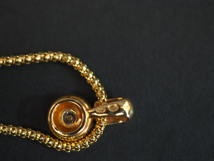 Pendentif en or jaune, orné en son centre d'un petit diamant serti clo
