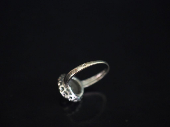 Bague ronde en or blanc, sertie en son centre d'un diamant entouré d'u