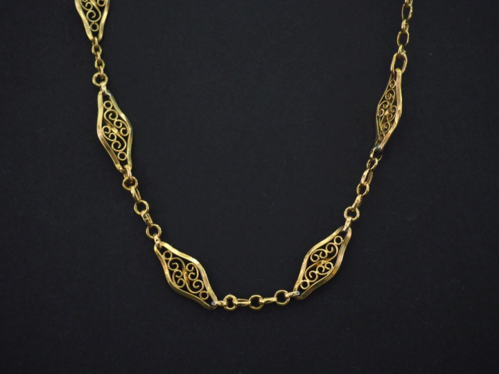 Collier souple en or jaune 750, composé de maillons ajourés et fligran