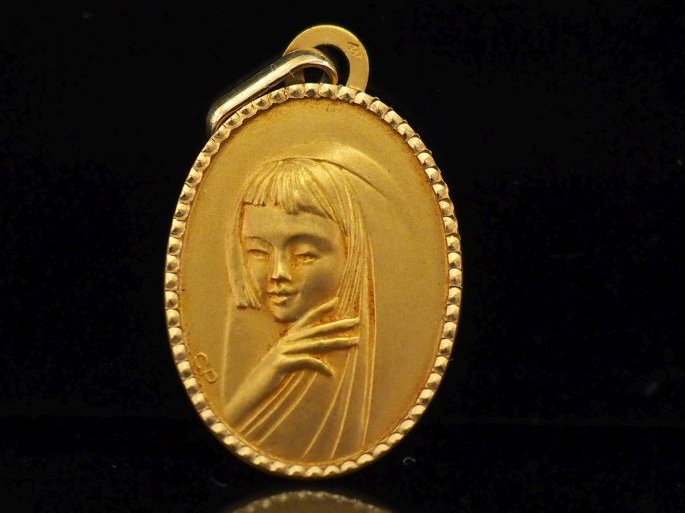 Médaille de forme ovale en or jaune 750, figurant une jeune femme au f