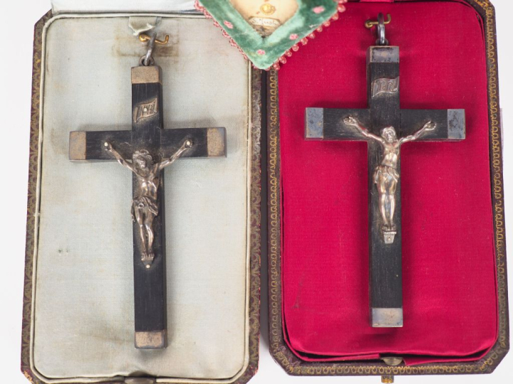 Deux crucifix en bois noirci et métal argenté dans leurs écrins gainés