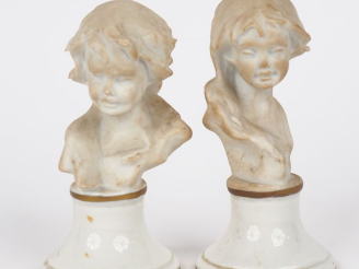 Vente aux enchères Paire de sujets en biscuit, "bustes d'enfants", sur des socles en porc