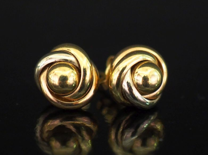 Paire de puces d'oreilles trois tons d'or 750, à décor d'entrelacs.  D