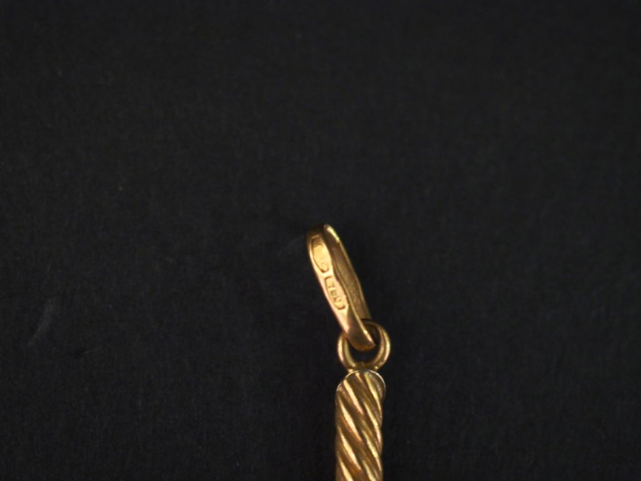 Pendentif en or jaune 750 en forme de croix, à décor de stries.  3,2 x