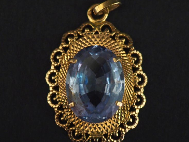 Pendentif ovale en or jaune 750, serti en son centre d'une pierre bleu