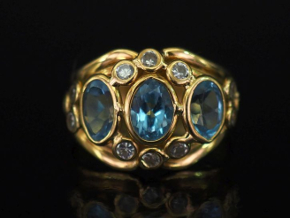 Vente aux enchères Bague bandeau ajourée en or jaune 750, sertie de trois pierres bleues 