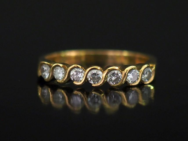 Demi alliance en or jaune 750, sertie d'une ligne de sept diamants.  T