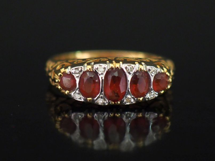 Bague jarretière en or jaune 750, sertie de cinq pierres roses en chut