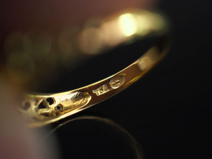 Bague jarretière en or jaune 750, sertie de cinq pierres roses en chut