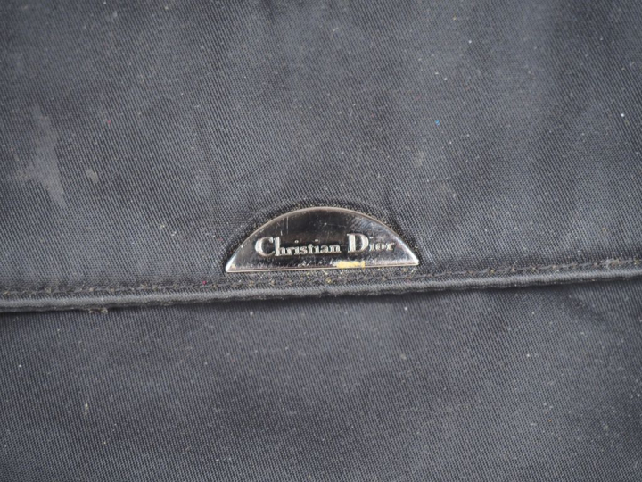 Christian DIOR,  Sac porté épaule en tissu noir. Fermeture à rabat et 
