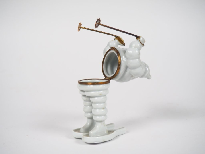 MICHELIN.  Bibendum skieur, boîte en porcelaine de Limoges. H. 14 cm.
