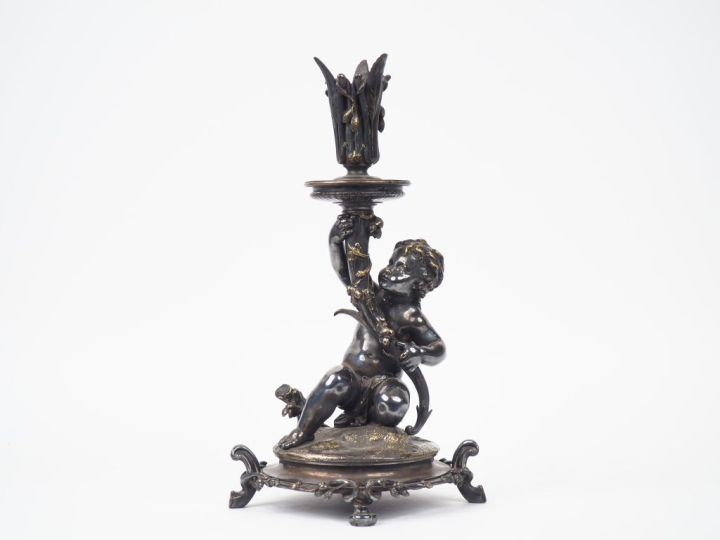 CHRISTOFLE.  Bougeoir en bronze argenté "Amour présentant une corne d'