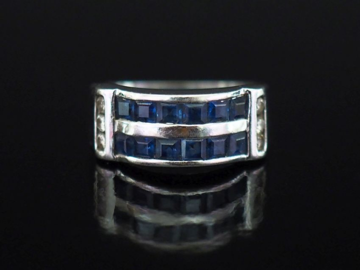 Bague pont en or blanc 750, sertie de deux lignes de saphirs calibrées