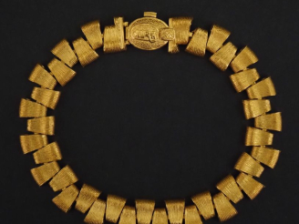 Vente aux enchères AURA,  Bracelet souple en or jaune 750, composé de maillons de forme t