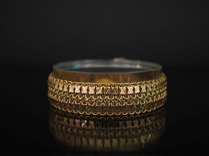 	Bracelet souple en or jaune 750, à décor de croisillons. Larg. 1,7 cm