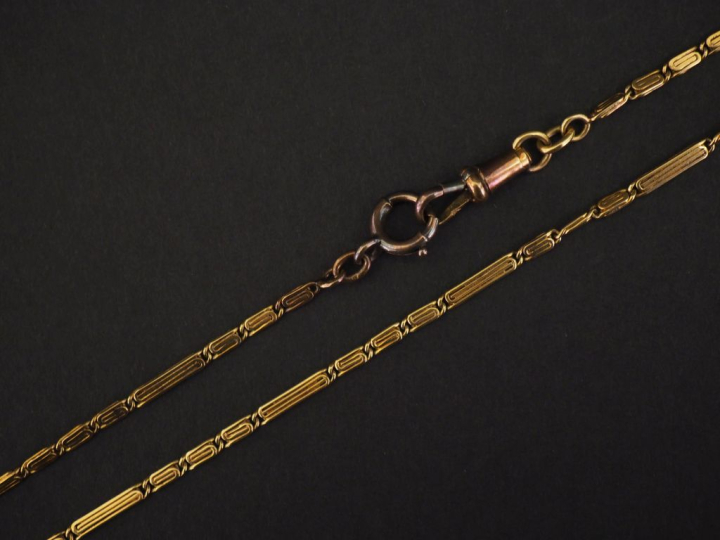 Petite giletière en or jaune 750, à décor de grecques.  Long. 34,5 cm 