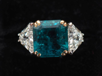 Vente aux enchères Bague en or blanc 750, sertie en son centre d'un émerauden de Colombie