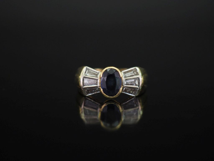 Bague nœud en or jaune 750, sertie en son centre d'un saphir épaulé de