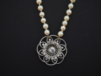 Vente aux enchères Collier de perles blanches, agrémenté en son centre d'une rosace ajour