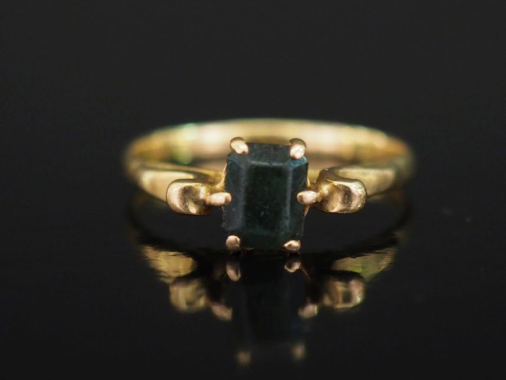 Bague en or jaune 750, sertie en son centre d'une pierre de couleur ép