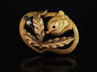 Vente aux enchères Broche ovale ajourée en or jaune 750, à décor d'une fleur et agrémenté