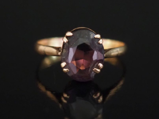 Vente aux enchères Bague en or jaune 750, sertie en son centre d'une pierre violette.  TD