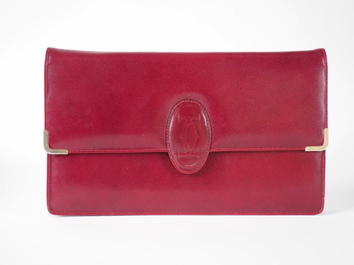 CARTIER Grande pochette en cuir bordeaux.  Fermeture à rabat et pressi