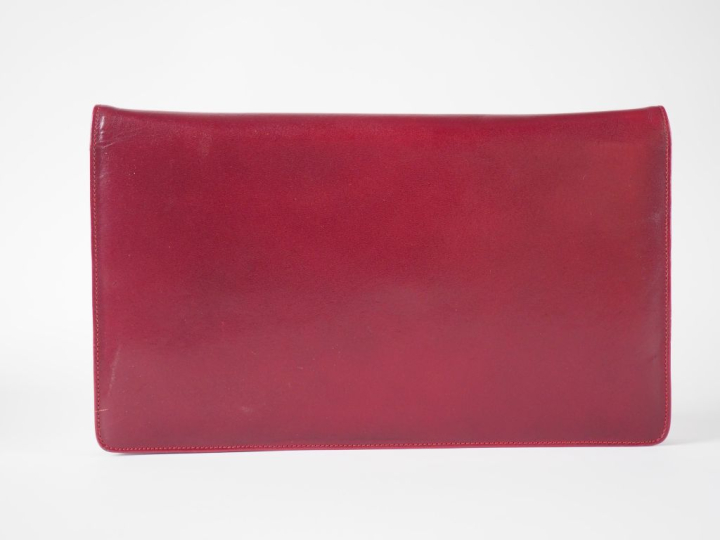 CARTIER Grande pochette en cuir bordeaux.  Fermeture à rabat et pressi