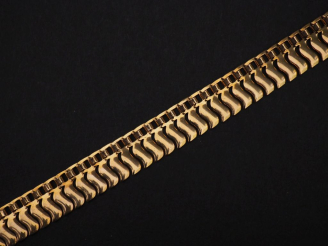 Vente aux enchères Collier souple en or jaune 750, à décor de vaguelettes.  Larg. 1,2 cm 
